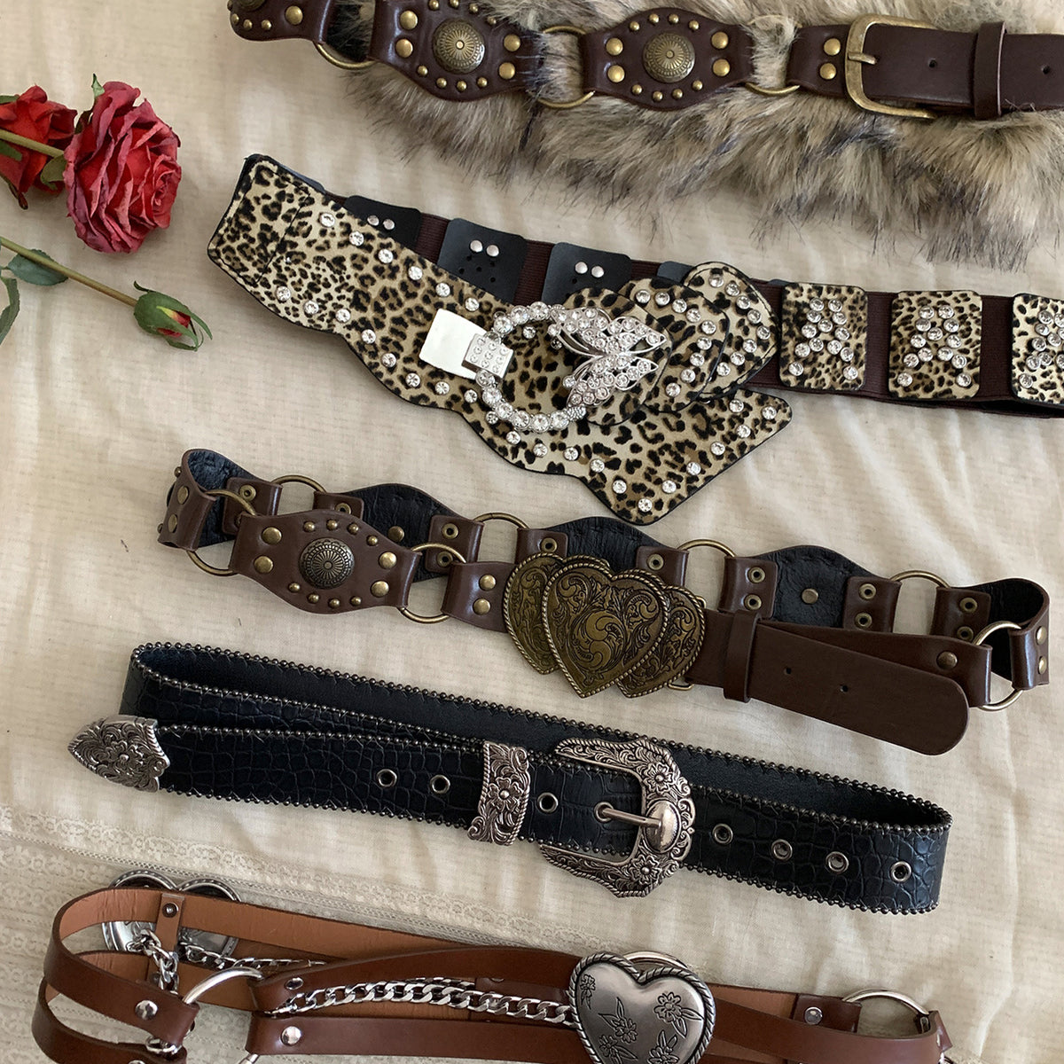 Collection of women’s Western statement belts featuring ornate buckles, rivets, animal print, and vintage-inspired details